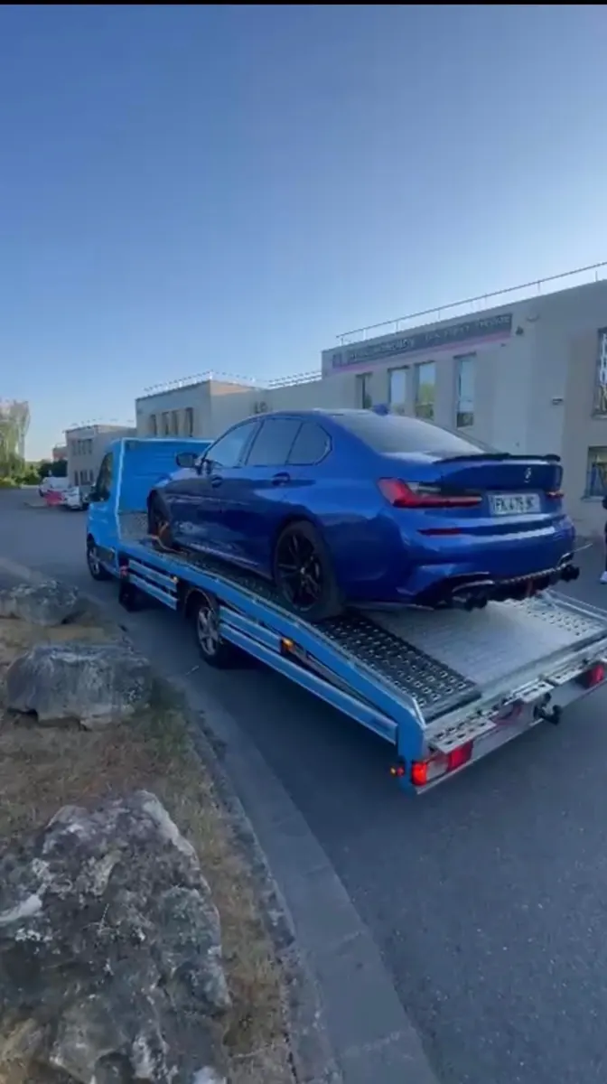 Blue Line Dépannage transportant un véhicule bleu sur plateau